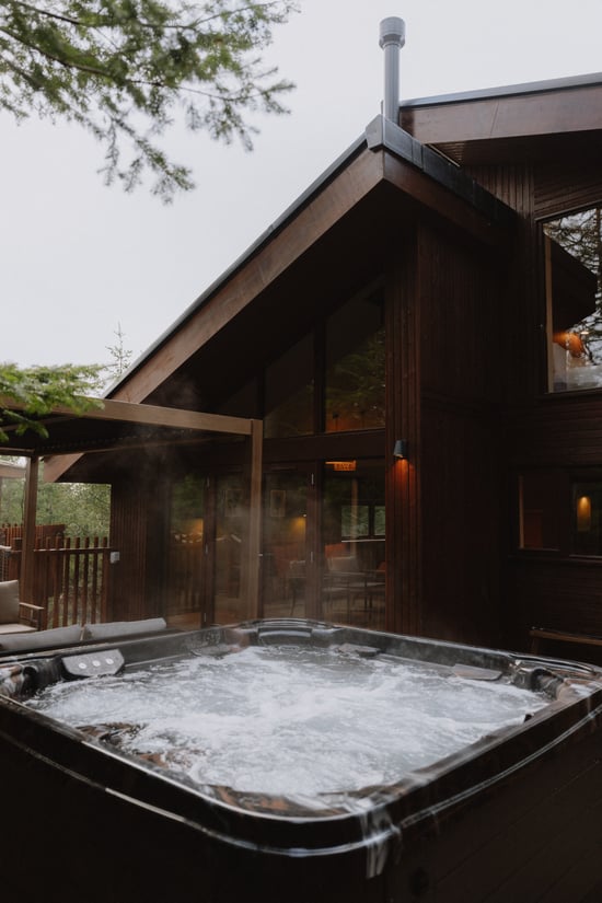 Unfurl cabin decking area with hot tub at Forest Holidays