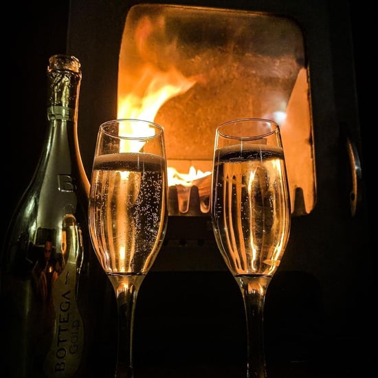 Glasses of prosecco in front of the log burner by @cefai