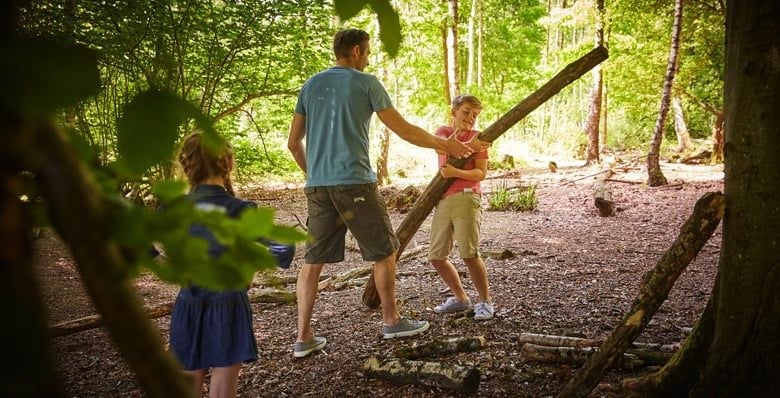 Family playing with sticks in the forest