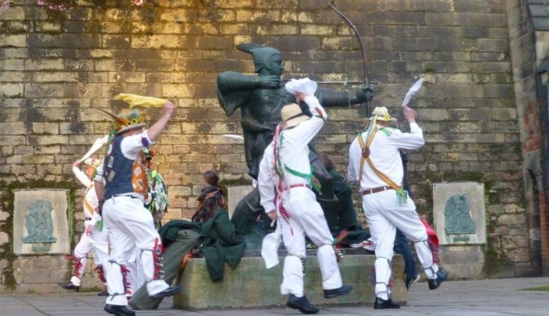Morris men dancing by Robin Hood statue in Nottingham