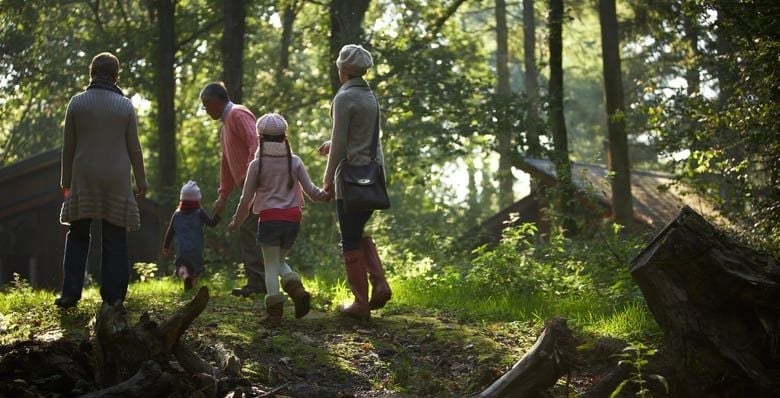 Family walks with grandparents through the forest