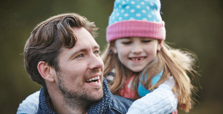 Father and child smiling outdoors