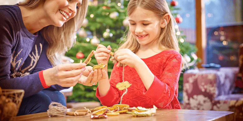 Mother and daughter making natural Christmas tree decorations at Forest Holidays