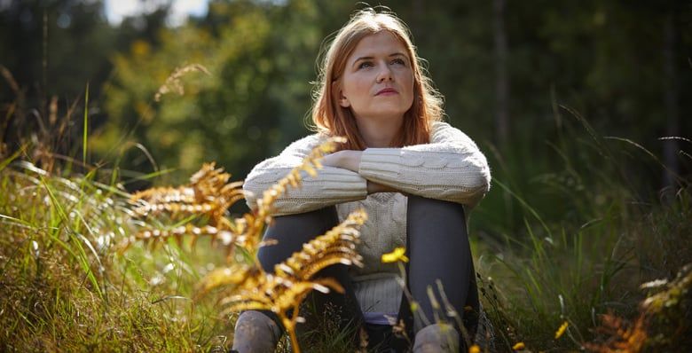Woman sat in an open meadow