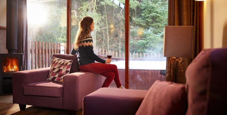 A woman relaxing in a Golden Oak cabin at Forest Holidays