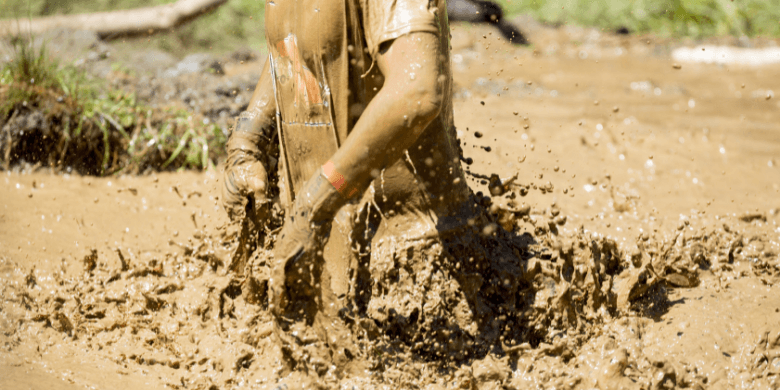 Man walking through deep mud