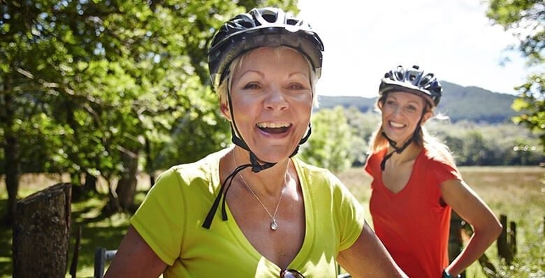 Two women wearing bike helmets