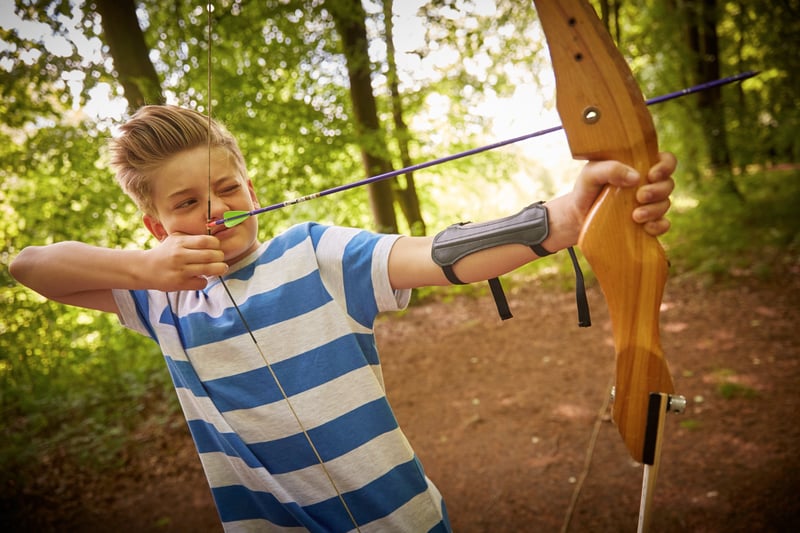 A boy trying out the archery activity at Forest Holidays on a archery holiday